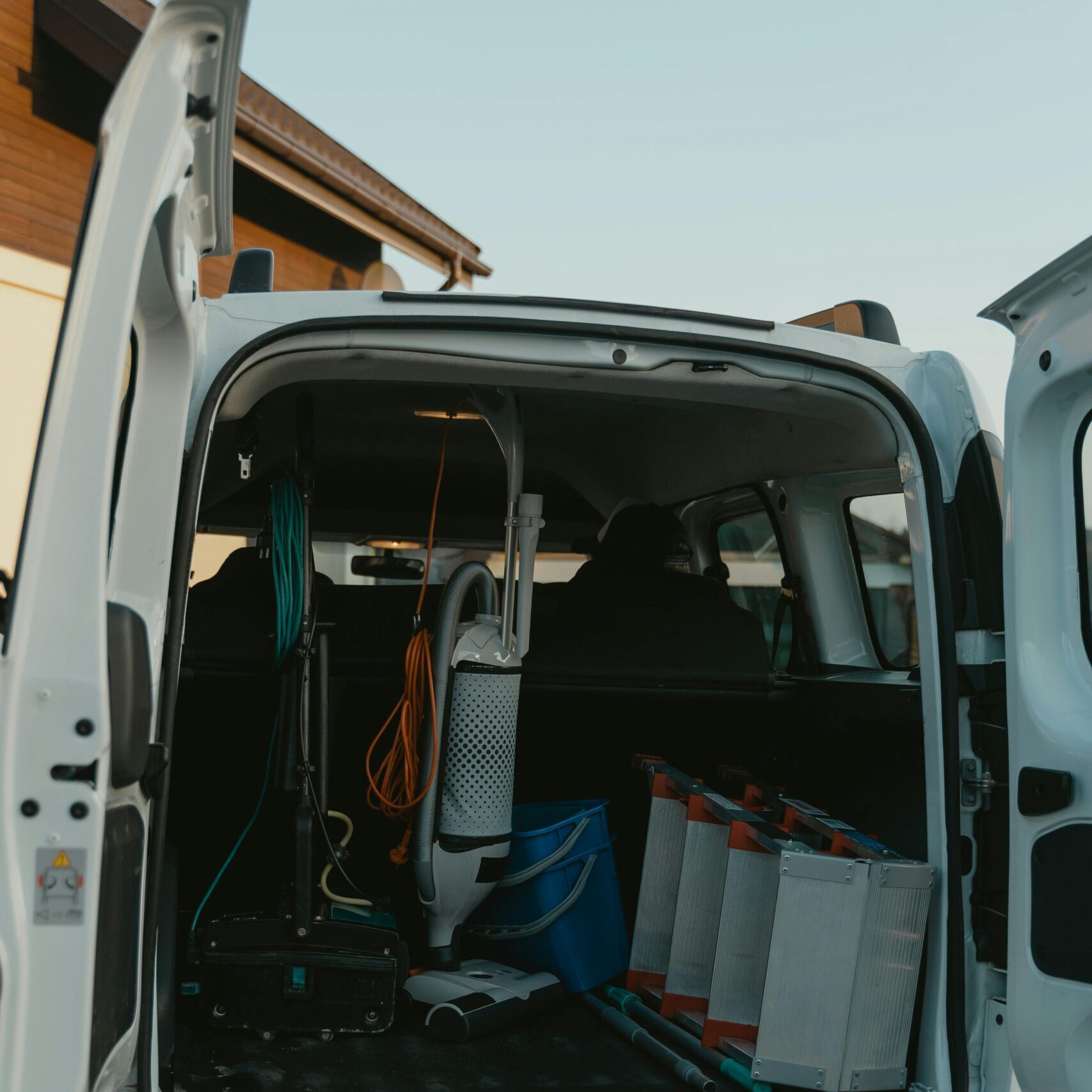 Rear view of open van showcasing cleaning equipment, ready for service.